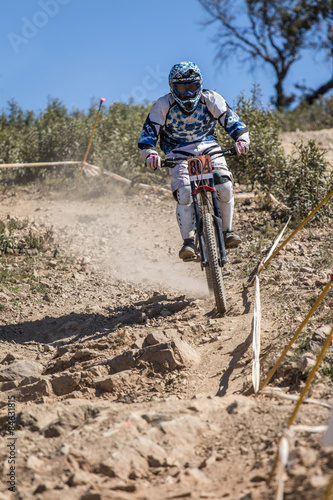 Downhill competition, Biker rides fast in the countryside.