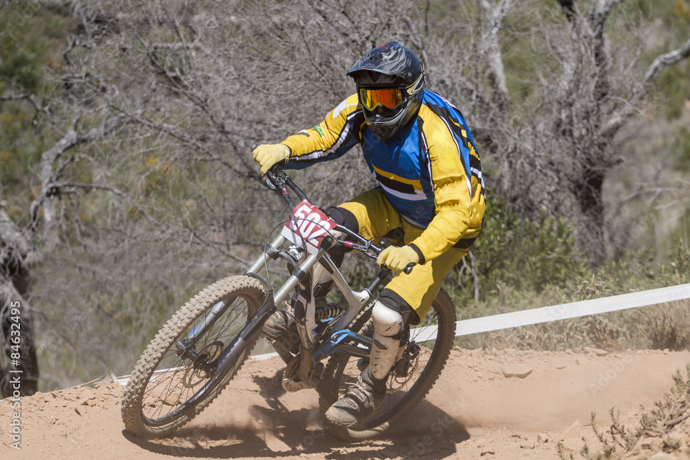 Fototapeta premium Downhill competition, Biker rides fast in the countryside.