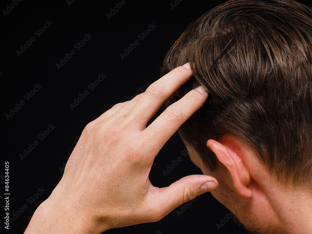 Fototapeta premium Closeup of a caucasian male thinking with one hand towards head