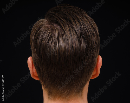 Rear view of hairstyle on male person with brown hair at closeup