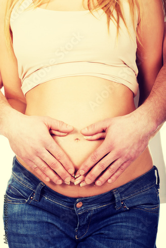 Man embracing her wife's pregnancy belly © Piotr Marcinski