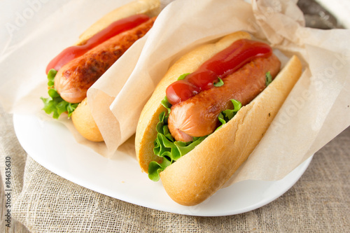 фотографія Hotdogs on white dish  wooden table