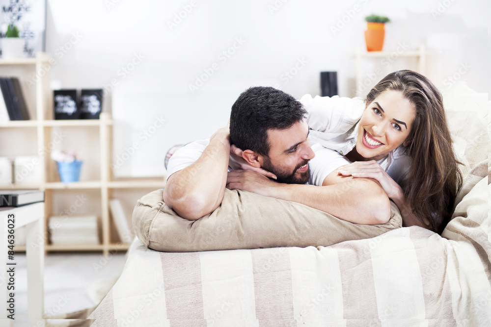 happy couple on bed sofa in living room happy couple on bed sofa in living room