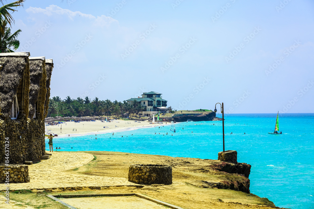 Great view of inviting Cuban beach and tranquil ocean with people in background Great view of inviting Cuban beach and tranquil ocean with people in background