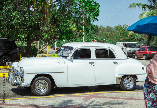  Old vintage classic car standing on the road in tropical garden