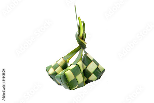Ketupat wrapped in coconut leaves on a white background.