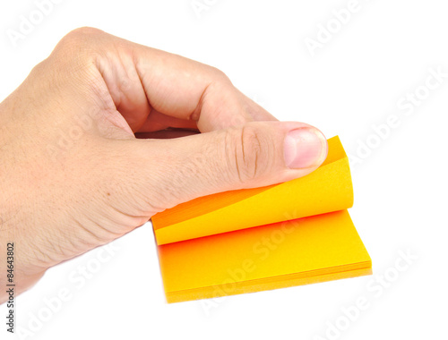 Hand with a block of yellow post it notes or notepapers on a