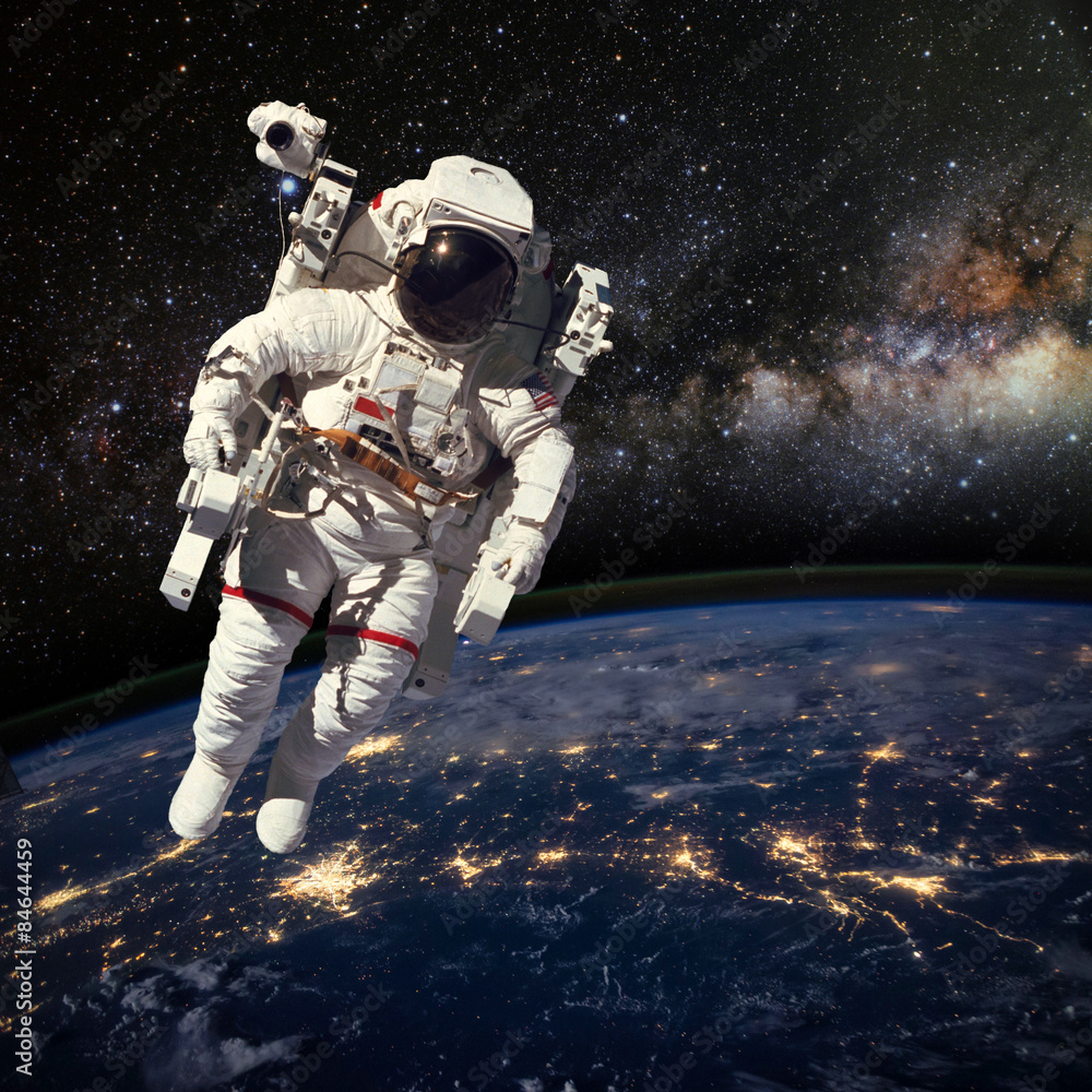 Fototapeta Astronauta w kosmosie nad ziemią w porze nocnej. Elem