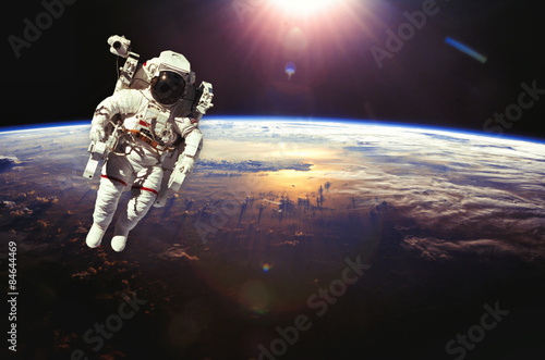 Astronaut in outer space above the earth during sunset. Elements #84644469