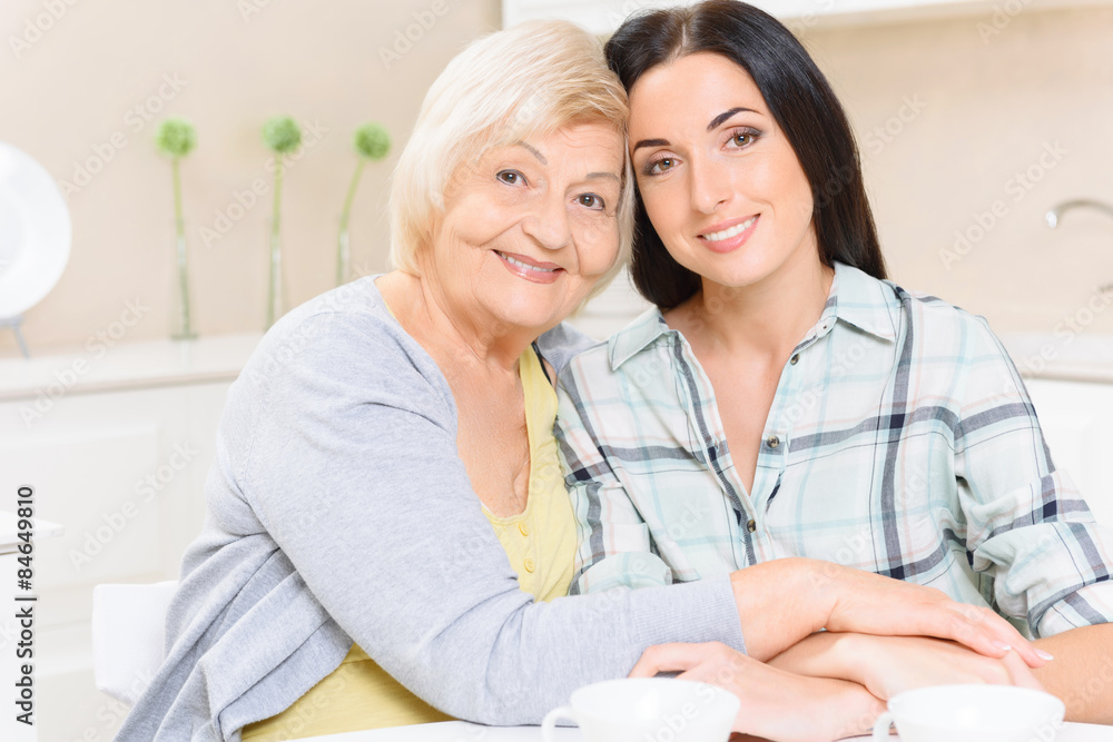 Grandmother and granddaughter sitting in kitchen Grandmother and granddaughter sitting in kitchen