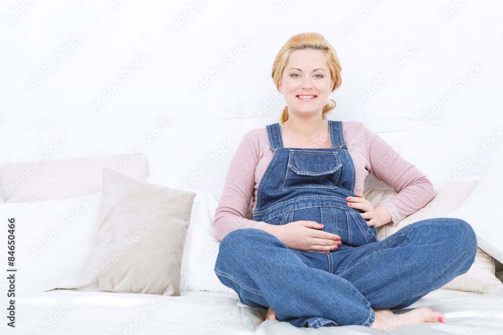 Obraz premium Pregnant smiling woman relaxing on the sofa