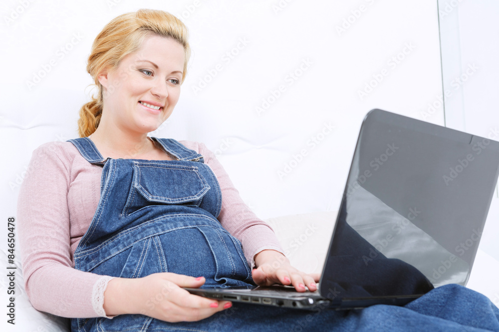 Naklejka premium Pregnant smiling woman relaxing on the sofa