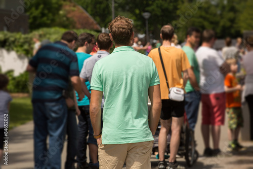 Mann steht vor wartender Gruppe