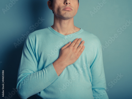 Young man with hand on his chest photo