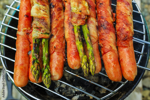 Grilled sausages and asparagus with bacon