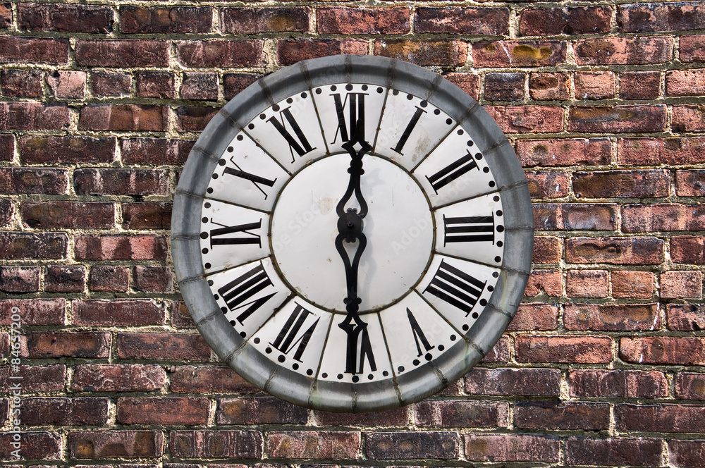 Vintage retro style clock on a red brick wall