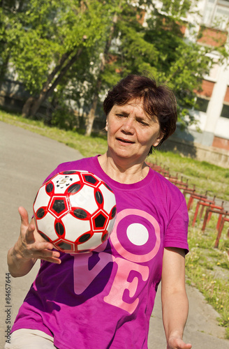   The woman  do exercises with a soccer ball.
