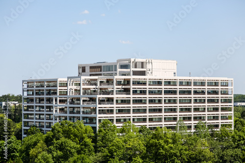 White Terraced Office Building Rising from Trees