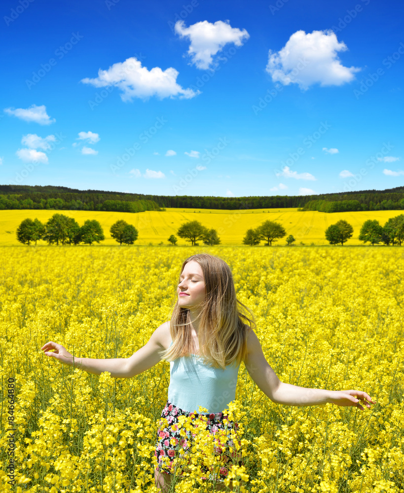 Young happy woman on blooming rapeseed field in spring Young happy woman on blooming rapeseed field in spring