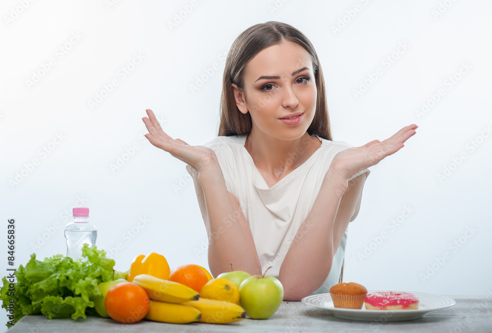 Beautiful young girl is choosing between healthy and unhealthy Beautiful young girl is choosing between healthy and unhealthy