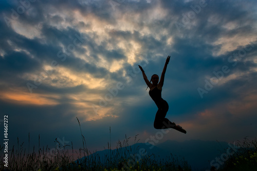 Jump in the mountains at dusk Girl in silhouette