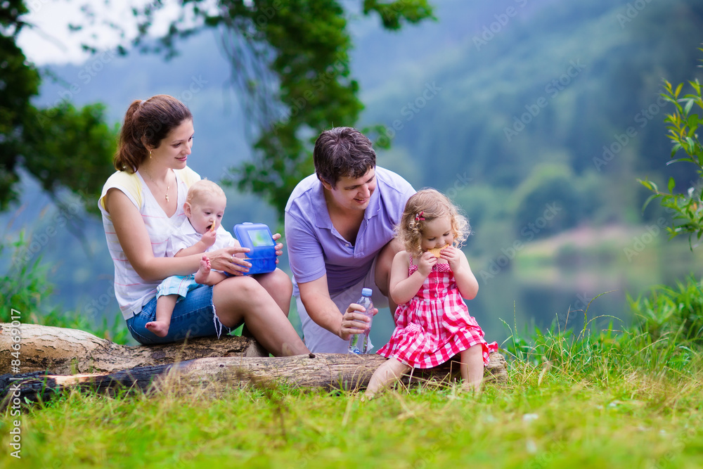 Fototapeta premium Young family with kids hiking at a lake