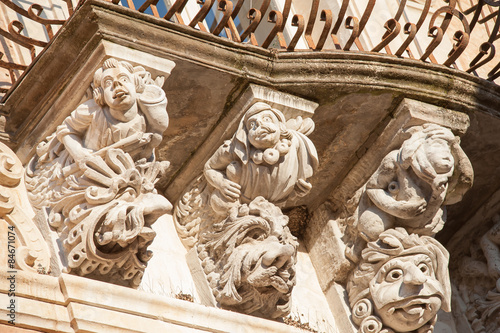 View of some typical baroque mascarons under the balconies of Cosentini Palace in Ragusa Ibla, Sicily photo