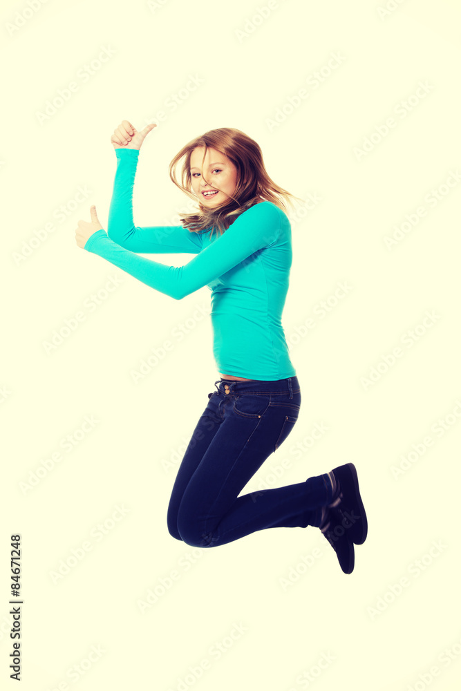 Young woman jumping with thumbs up Young woman jumping with thumbs up