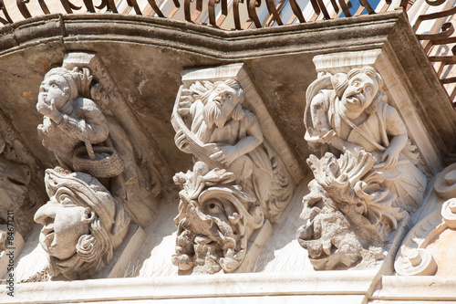 View of some typical baroque mascarons under the balconies of Cosentini Palace in Ragusa Ibla, Sicily
