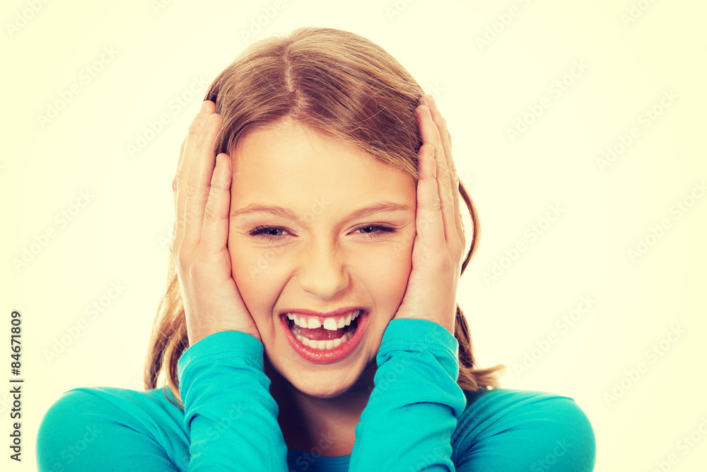 Excited young woman holding her head Excited young woman holding her head