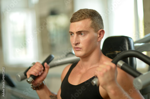 Young man exercises in gym