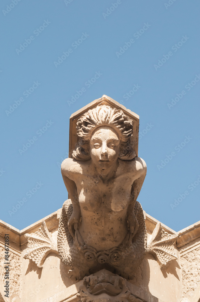 Ornamental sculpture of a mermaid on the roof of a Baroque palace in Lentini, Sicily