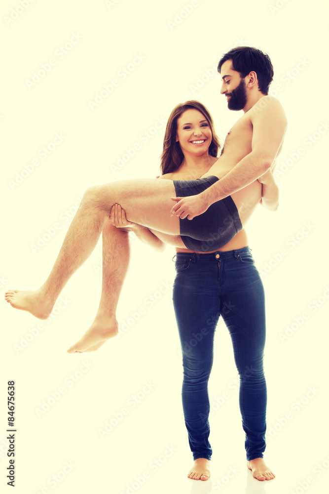 Young woman carrying man on her arms. Young woman carrying man on her arms.