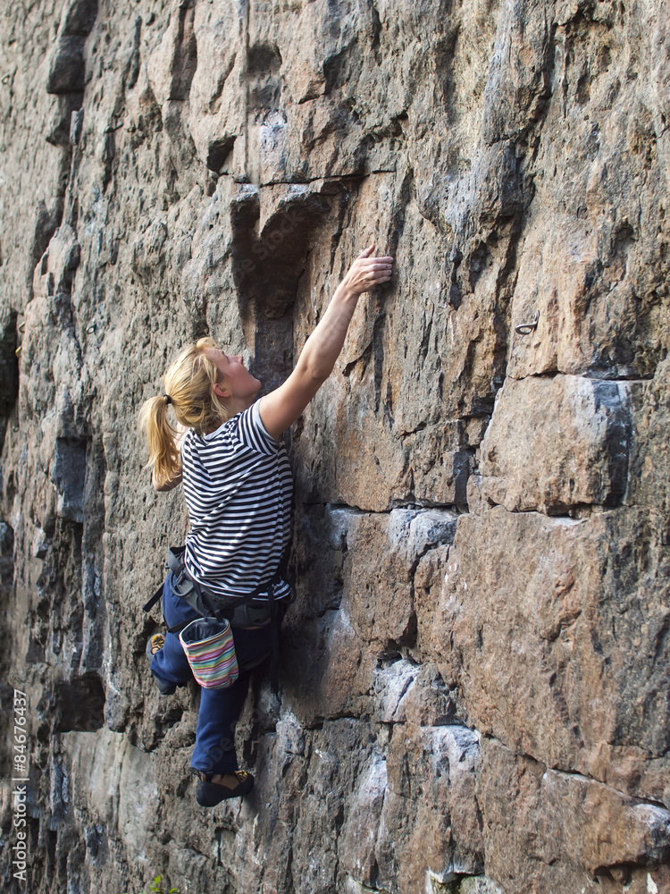 Young woman with rope climbs on the rock. Young woman with rope climbs on the rock.