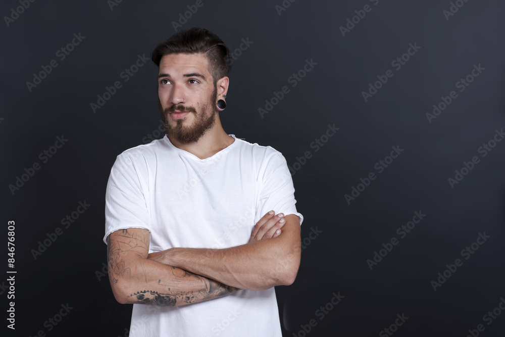 Junger bärtiger Mann blickt nachdenklich zur Seite Junger bärtiger Mann blickt nachdenklich zur Seite