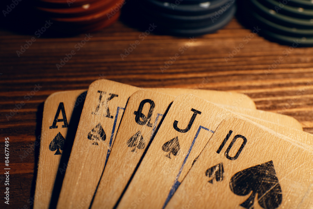 Fototapeta premium Playing cards with chips on wooden table, closeup