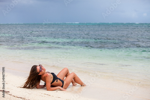 Young girl lie on the ocean beach
