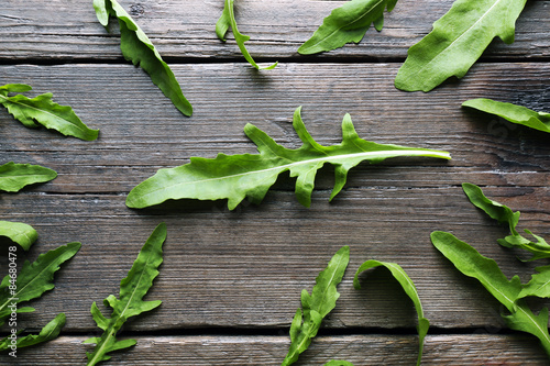 Green arugula leaves on wooden table