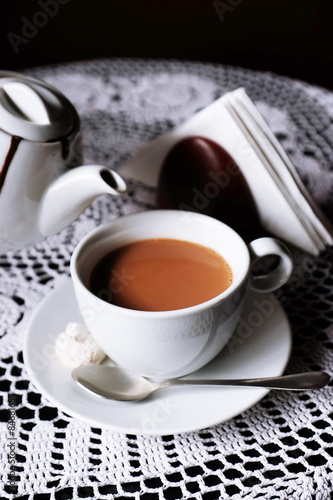 Hot chocolate in mug, on table, on dark background