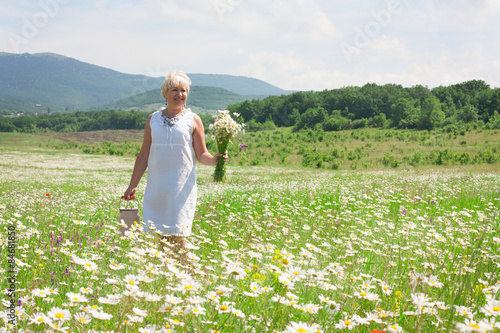 Senior woman having fun on the flower field