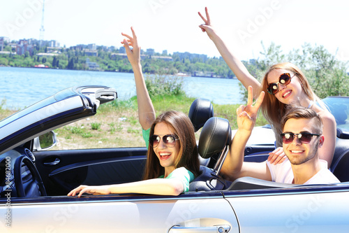Three friends in cabriolet, outdoors © Africa Studio