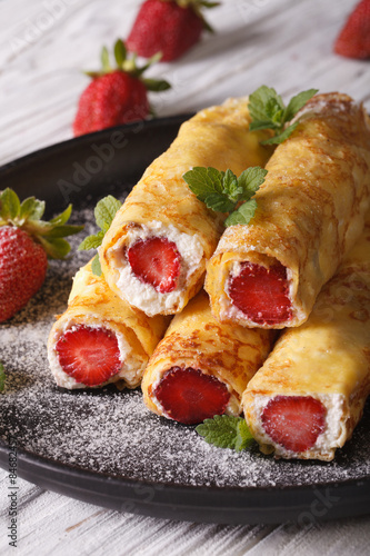 crepes with strawberries and cream cheese close-up. vertical 
