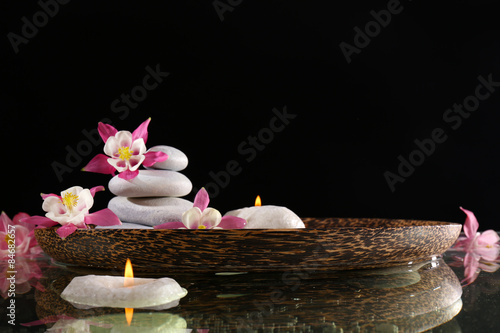 Spa still life with flowers and candlelight on black background