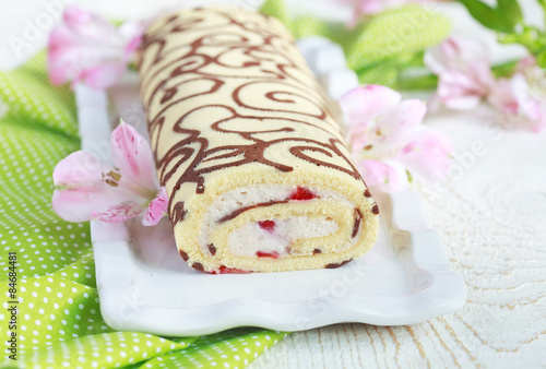 Homemade sponge roll with chocolate patterns, strawberries photo