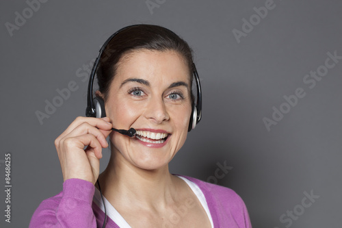 30s smiling businesswoman speaking on the phone with a headset