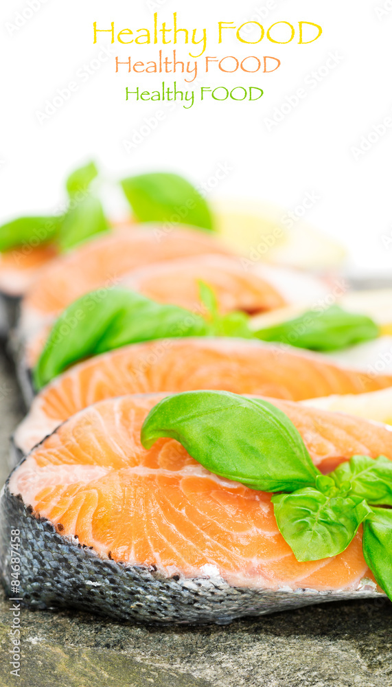 Salmon on stone with basil and lemon isolated on white Salmon on stone with basil and lemon isolated on white