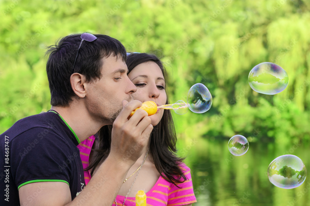 couple having fun with soap bubbles in the park couple having fun with soap bubbles in the park