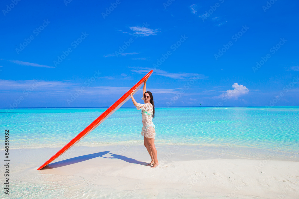 Happy beautiful surfer woman at white beach with her surfboard