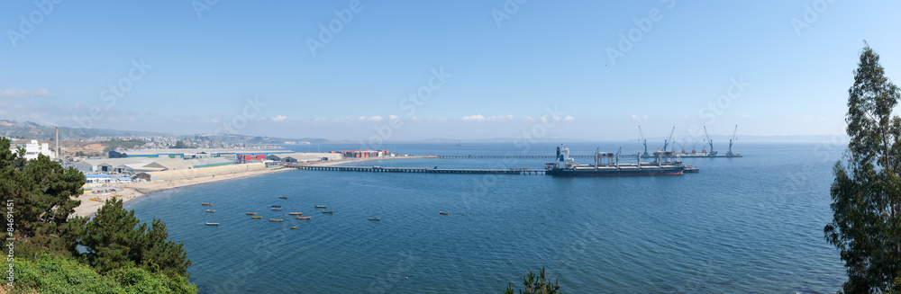 Cargo ships under loading in the port in bright sunny day