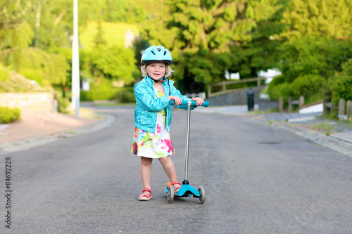 Wallpaper Mural Preschooler girl riding scooter outdoors. Happy cute little child wearing blue safety helmet playing on the street learning to balance on kick board in the countryside Torontodigital.ca